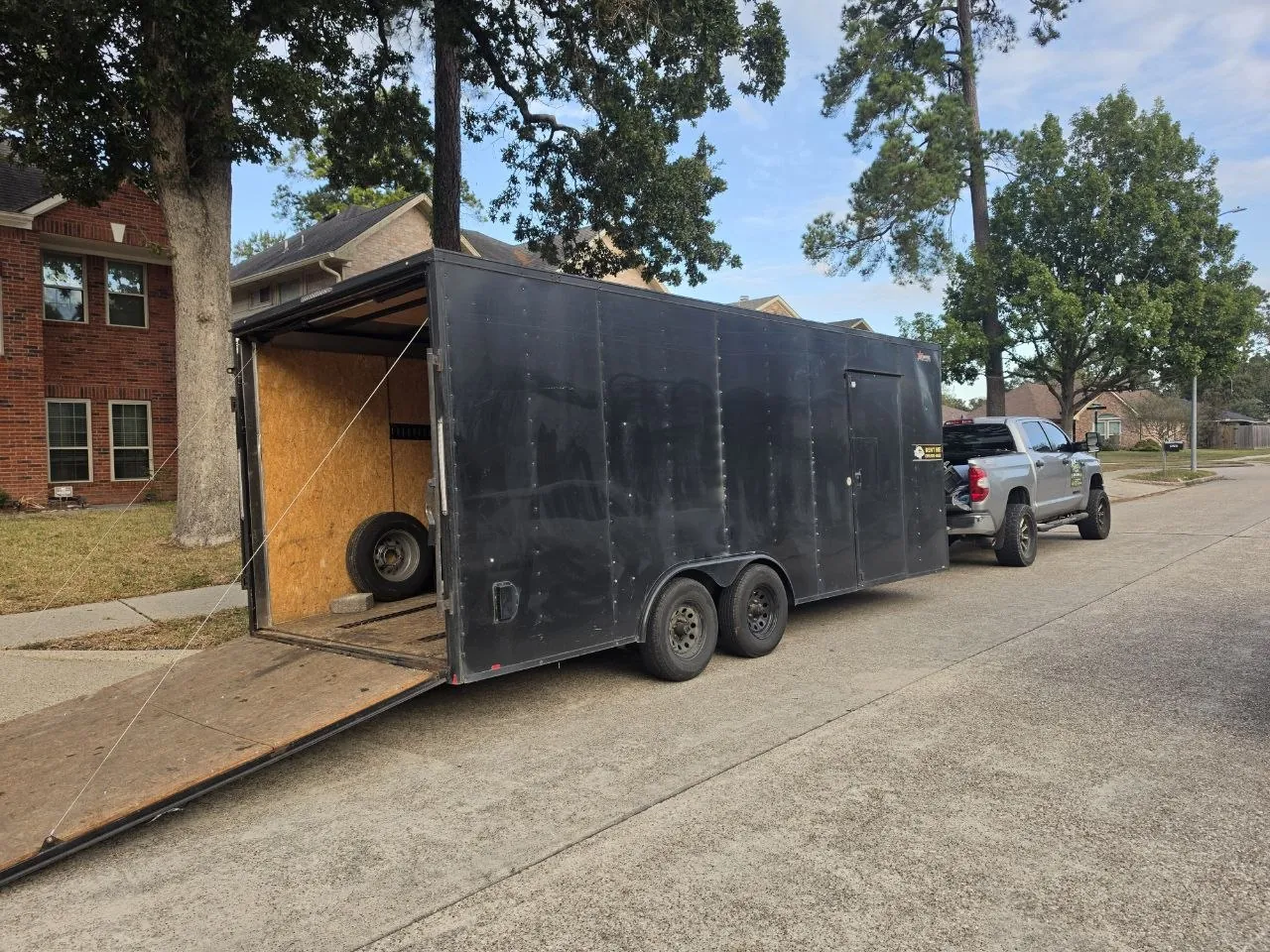 Junk Junkies Texas moving trailer and truck parked on a Spring, TX street